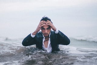 man in suit half-buried in water