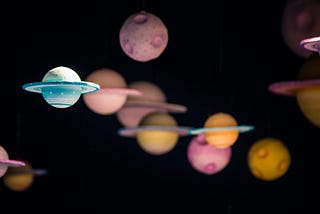 multi-colored planets and other celestial bodies floating within black space