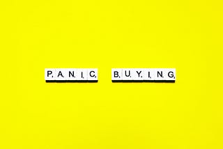 Panic Buying words spelled on a bright yellow background — depicting psychological traps of online shopping