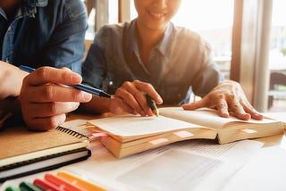 A group of writers engaged in their craft, symbolizing the search for affordable ghostwriting services in 2024. The focus is on their concentrated expressions and busy hands as they write, representing the diligence and skill required in ghostwriting. The image conveys the essence of the title ‘How to find affordable ghostwriting services in 2024’.