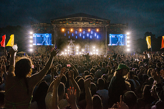 The main stage at night time at Tramlines with a crowd of people.