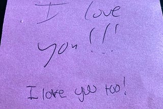 A pink post-it with the words “I love you” and “I love you too!”