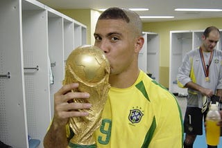 Ronaldo Nazario of Brazil kissing the World Cup trophy in the locker room.