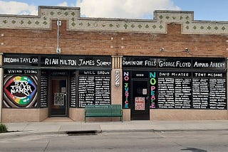 Image of more than 100 names of slain Black people on storefront windows in Benson Business District, Omaha, NE, July 4, 2020