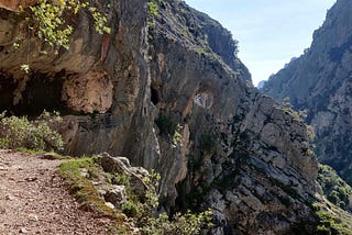 Me hiking on Ruta del Cares with a cave in the background