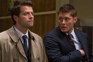 A screen-grab of Supernatural, wherein Dean on the right of the image looks at Castiel, on the left