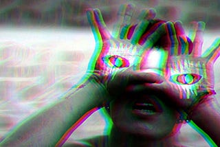 person holds hands to face, palms pointed outward. palms are painted with images of open eyes. they are positioned roughly where the person’s real eyes are (beneath their hands). the effect is kind of cool but also creepy.