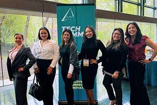 Group of Latina tech leaders standing in front of a banner