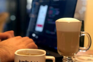 Programmer hands on yhe pc and a cup of coffee with the text love.