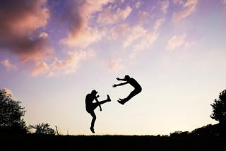 A man is sent flying through the air, presumably from a hard kick in the pants, against the backdrop of a beautiful sunrise