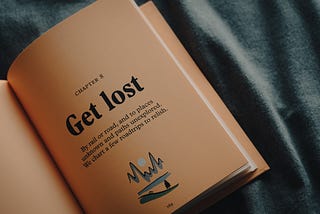 A picture of a book saying to get lost to places unknown and paths unexplored.