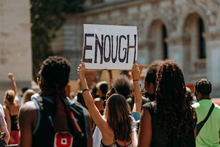 Protester Holding a Sign With the Word Enough