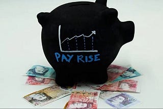 A picture of a black piggy bank with a upwards trending graph on the side and the words “pay rise” on top of a variety of Australian bank notes.