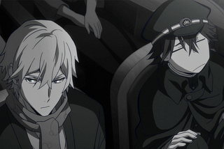 From the anime “Bungo Stray Dogs,” this black and white image shows the modern samurai Fukuzawa and his kid sidekick Ranpo watching a play. Fukuzawa looks off to the side while Ranpo graimces, looking confused and put-off by the play. Fukuzawa wears a cloak and Ranpo wears a Japanese school uniform and matching cap. Ranpo has his legs pulled up as he crouches on the theater seat.