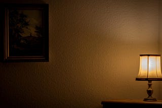 a single lamp and a framed painting