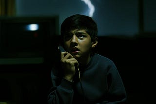 A boy listening to a prank caller reveal something disturbing.