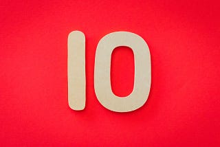 O número dez em papel posicionando em cima de um fundo vermelho.