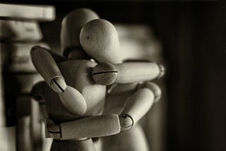 Two wooden dummy figures hugging