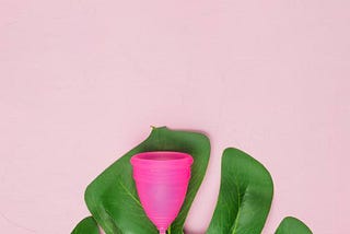 A pink menstrual cup with a leaf.