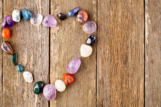 Heart made of gemstones on a wooden table