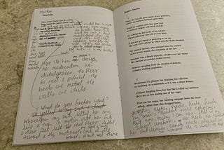 Open poetry book with pencil scribblings.