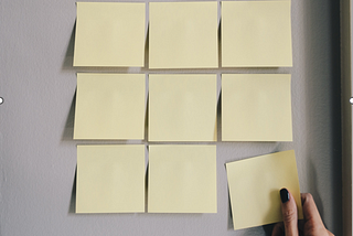 A 3 by 3 row of square blank yellow sticky notes.