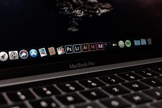 Laptop screen showing Adobe Creative Cloud apps