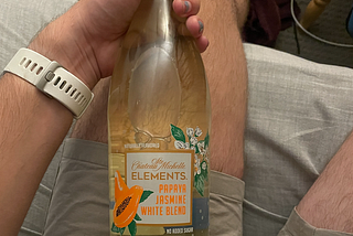 One bottle of CSM Elements (Papaya Jasmine White Blend) being held by a hand with periwinkle nails