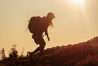 Hiker woman carrying a heavy backpack exhausted during the ascent. An active, healthy lifestyle is beneficial though beginnings can be tough.