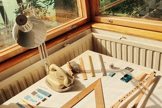 Table, lamp, and the architect’s material next to the window