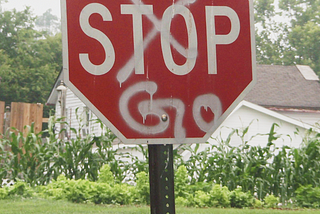 A Stop sign with the word “Stop” crudely crossed out and replaced with spray painted “Go”