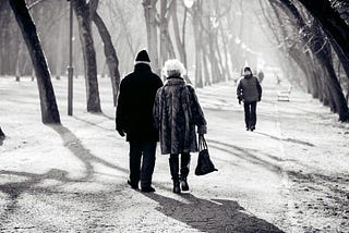 elederly couple walking together in a park