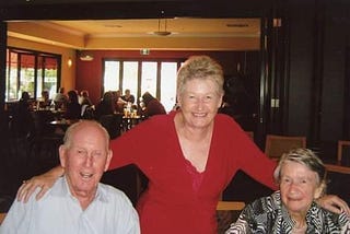 Lesley Dewar in a red top, with her Mum and Dad at his 95th birthday lunch