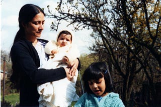 A small child and a woman holding a baby.