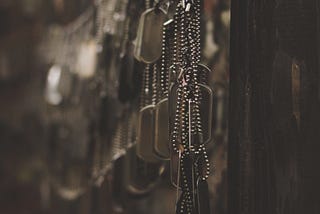 A photograph showing many military dog tags hanging