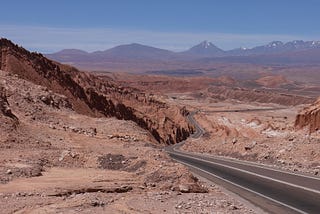 A road going down a desert valley in the Atacama Desert