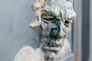 Photo by Julia Volk: https://www.pexels.com/photo/stone-mascaron-on-old-gate-with-ornament-5273207/