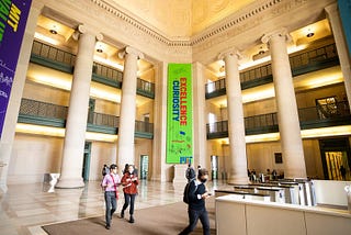 MIT’s main lobby, with a few people walking through it.