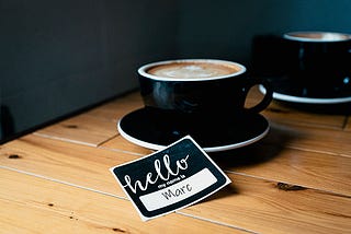 Coffee Cup and Name Tag on Table