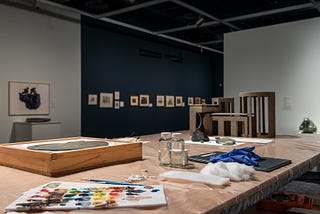 An inside view of an art gallery with a conservation table in the forefront.