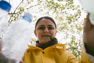 Woman putting plastic bottles in recycle bins