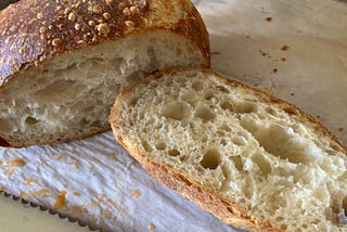 Homemade sourdough loaf cut to expose texture of crust and bread.