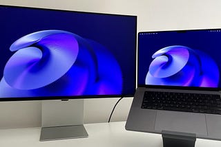 The Samsung monitor on the left, with a 16″ M1 MacBook Pro connected to its right.