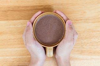 Hands holding cup of hot chocolate on wooden table. Photo 194629794 | Cafe © Natthawut Thongchomphoonuch | Dreamstime.com