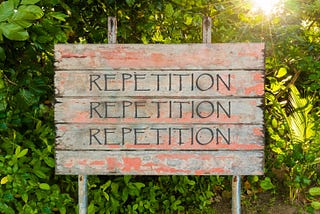Sign that says Repetition Repetition Repetition
