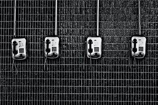 four interesting silver telephones on a black and white grid background taken by @eduardoequis on Unsplash