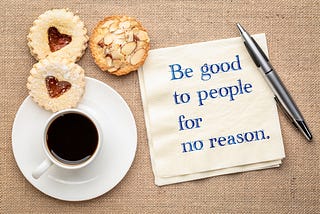 A warm display featuring coffee and cookies, accompanied by the message: “Be good to people for no reason.”