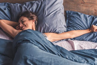 happy, well-rested woman waking up stretching