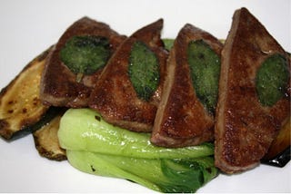 Color photo of liver and onions with broccoli on the side.