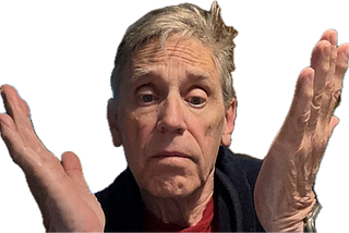 A person with short gray hair is raising both hands in a confused or uncertain gesture.